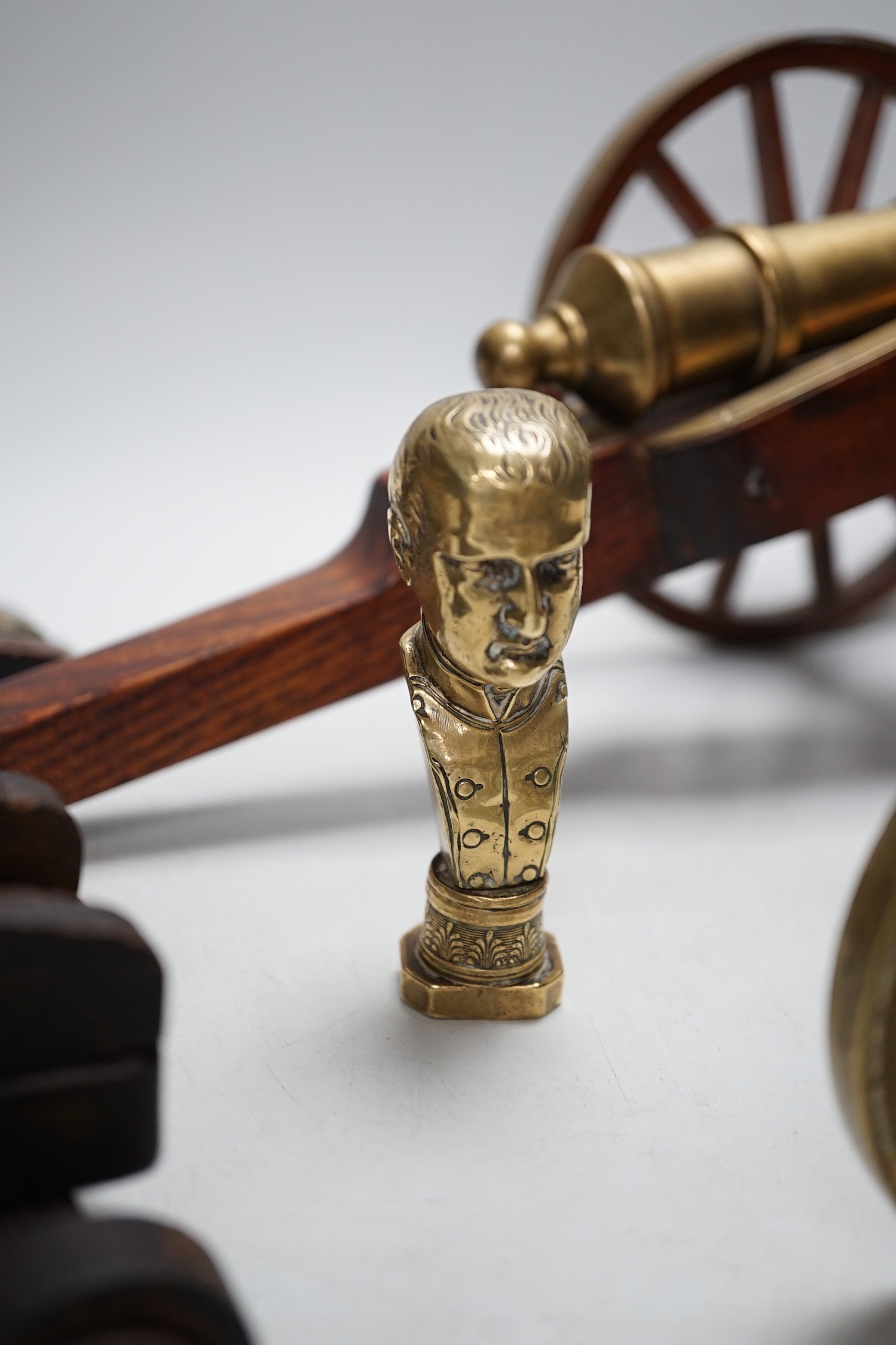A bronze 'Napoleon bust' desk seal, 8.5cm tall, together with four models of cannons. Largest 39cm wide